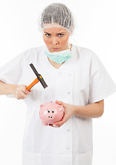 Image showing a woman doctor breaks his piggy bank with a hammer