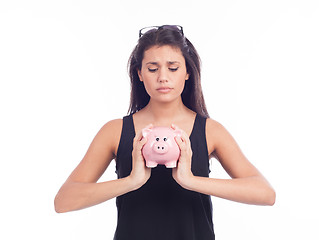 Image showing Young woman worried with a piggy bank