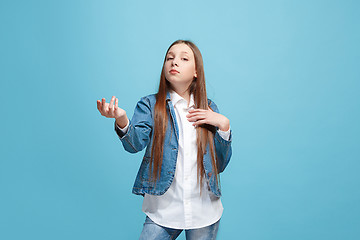 Image showing Beautiful female half-length portrait on blue studio backgroud. The young emotional teen girl