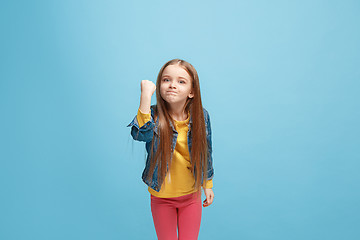 Image showing Portrait of angry teen girl on a blue studio background