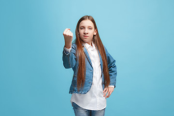 Image showing Portrait of angry teen girl on a blue studio background