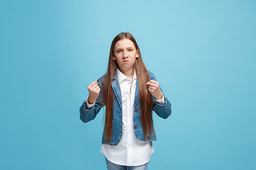 Image showing Portrait of angry teen girl on a blue studio background