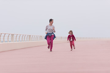 Image showing mother and cute little girl on the promenade by the sea