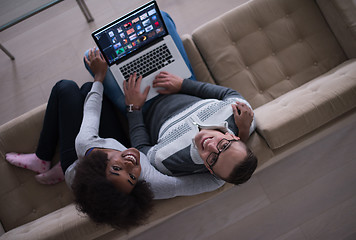 Image showing happy multiethnic couple relaxes in the living room