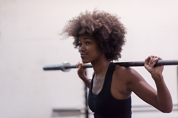 Image showing black woman lifting empty bar