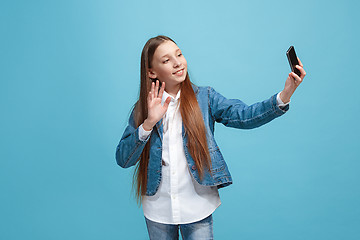 Image showing The happy teen girl standing and smiling against pink background.