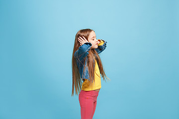 Image showing Beautiful female half-length portrait on blue studio backgroud. The young emotional teen girl