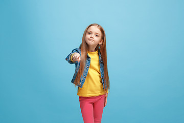 Image showing The happy teen girl pointing to you, half length closeup portrait on blue background.