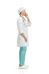 Image showing Beautiful young woman in white coat posing at studio. Full length studio shot isolated on white.