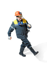 Image showing The studio shot of senior bearded male miner standing at the camera on a white background.