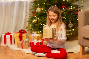 Image showing smiling girl with christmas gift at home