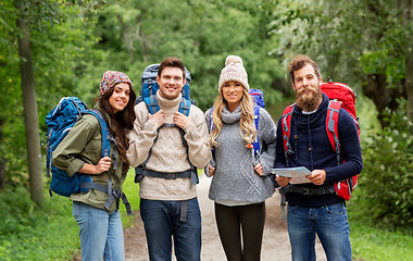 Image showing friends or travelers hiking with backpacks and map