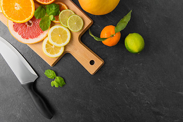 Image showing close up of fruits and knife on slate table top