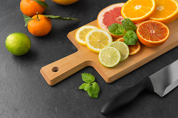 Image showing close up of fruits and knife on slate table top