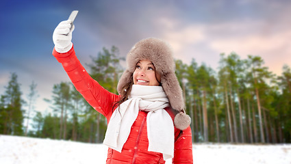 Image showing happy woman taking selfie over winter forest