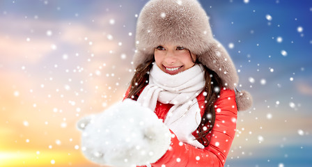 Image showing happy woman with snow in winter fur hat outdoors