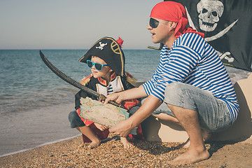 Image showing Father and son playing on the beach at the day time.