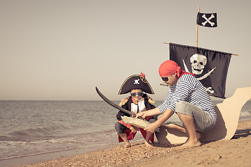 Image showing Father and son playing on the beach at the day time.