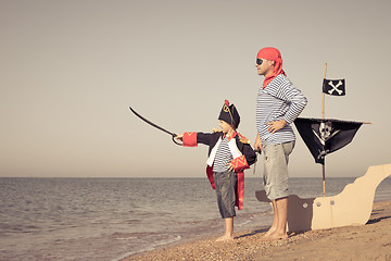 Image showing Father and son playing on the beach at the day time.