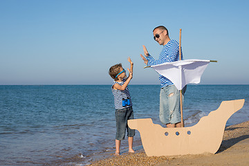 Image showing Father and son playing on the beach at the day time.