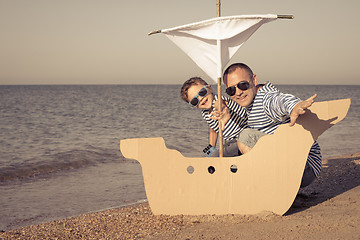 Image showing Father and son playing on the beach at the day time.