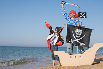 Image showing Father and son playing on the beach at the day time.