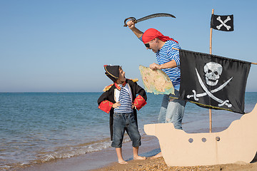 Image showing Father and son playing on the beach at the day time.