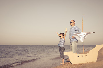 Image showing Father and son playing on the beach at the day time.