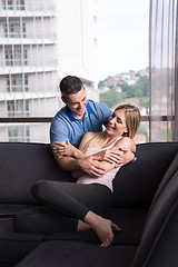 Image showing young handsome couple hugging on the sofa