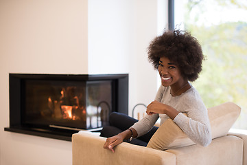 Image showing black woman in front of fireplace