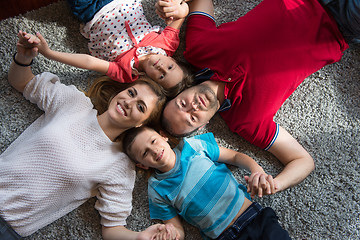 Image showing happy family lying on the floor