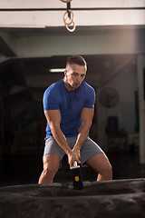 Image showing man workout with hammer and tractor tire