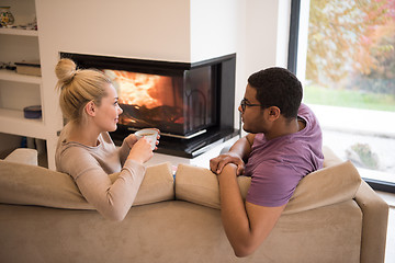 Image showing Young multiethnic couple  in front of fireplace