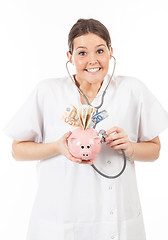 Image showing happy woman doctor with piggy bank full of money