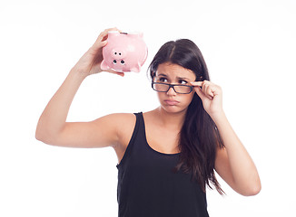 Image showing Young woman worried with a piggy bank