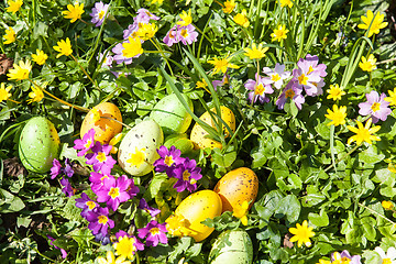 Image showing colored Easter eggs hidden in flowers and grass