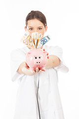 Image showing A woman shows a piggy bank full of European banknotes