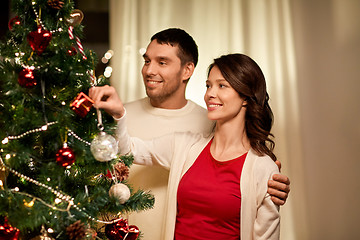 Image showing happy couple decorating christmas tree at home