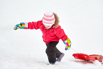 Image showing girl with sled climbing snow hill in winter