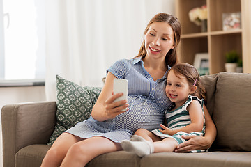 Image showing pregnant mother and daughter with smartphone