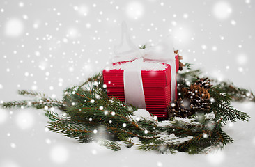 Image showing christmas gift and fir wreath with cones on snow