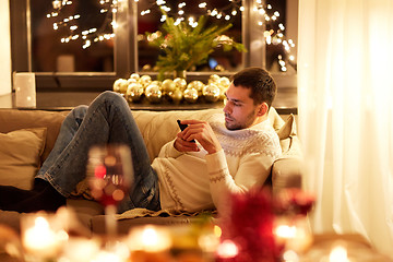 Image showing man with smartphone at home at christmas eve