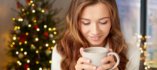 Image showing happy woman with cup of tea or coffee on christmas