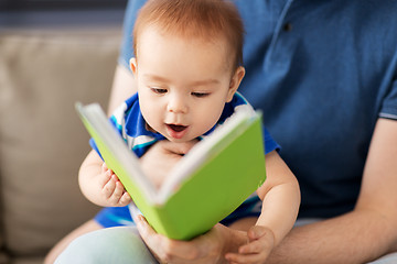 Image showing close up of baby boy and father with book at home