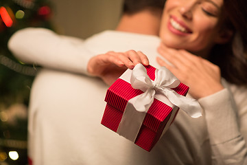 Image showing close up of couple with christmas gift hugging