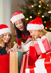 Image showing women in santa hats with gifts on christmas