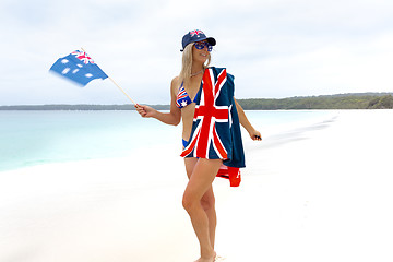 Image showing Aussie girl waving Australian flag on stunning pristine beach