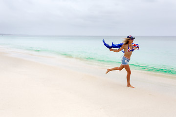 Image showing Australian woman running along beach