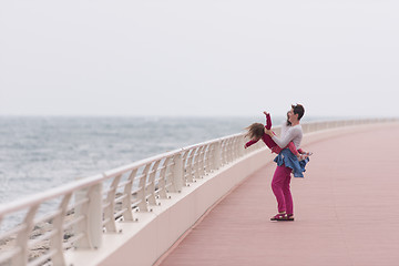 Image showing mother and cute little girl on the promenade by the sea