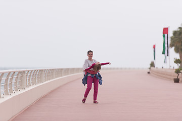 Image showing mother and cute little girl on the promenade by the sea